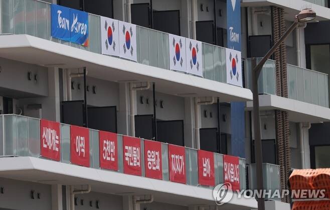 "Not yet to God" banner hanging in the athletes' village.Daily "anti-Japanese symbol" backlash