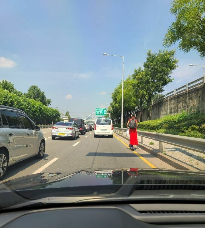 Motorized kickboard girl on the main road