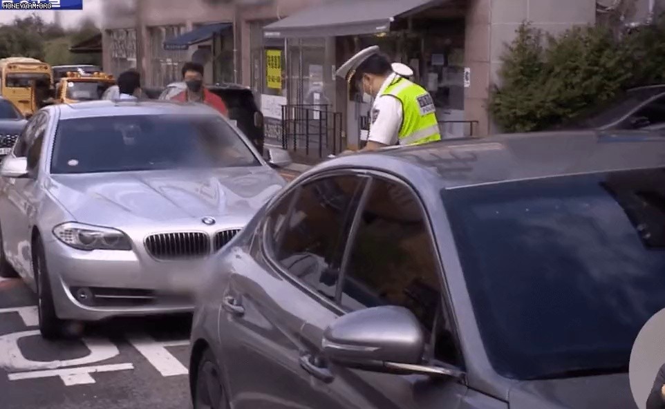 The mother of a child who's breaking a traffic light and tapping the police.