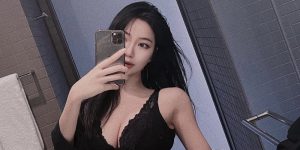 A selfie in a black bra in the bathroom.
