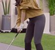 Golf swing wearing schizophrenic leggings.