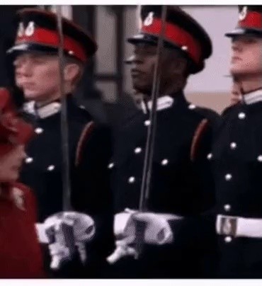 A soldier who smiles in front of the Queen of England