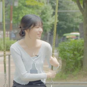 JO YU RI sitting on the swing wearing a gray super mini and smooth thigh