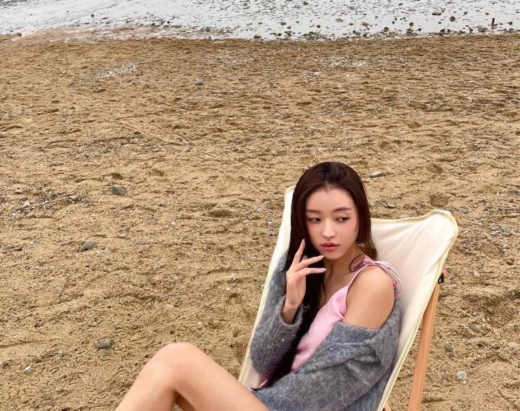 A pink string dress sitting on a sunbed by the sea. Oh My Girl, angular beauty