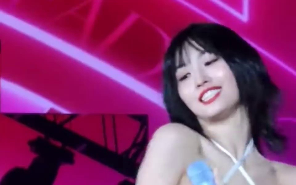 TWICE Momo adjusting the position of the tank top bra with the sexy halter neck