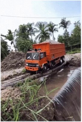 A truck with sand crosses a log bridge, eventually