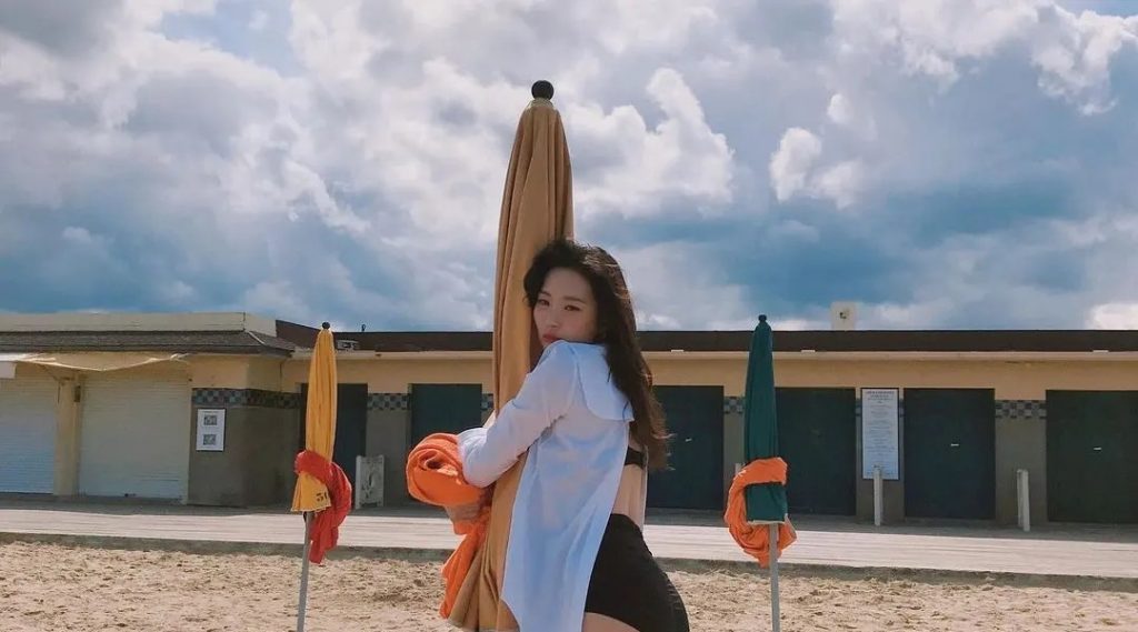 Sunmi's black bikini hipline hugging parasols at the beach