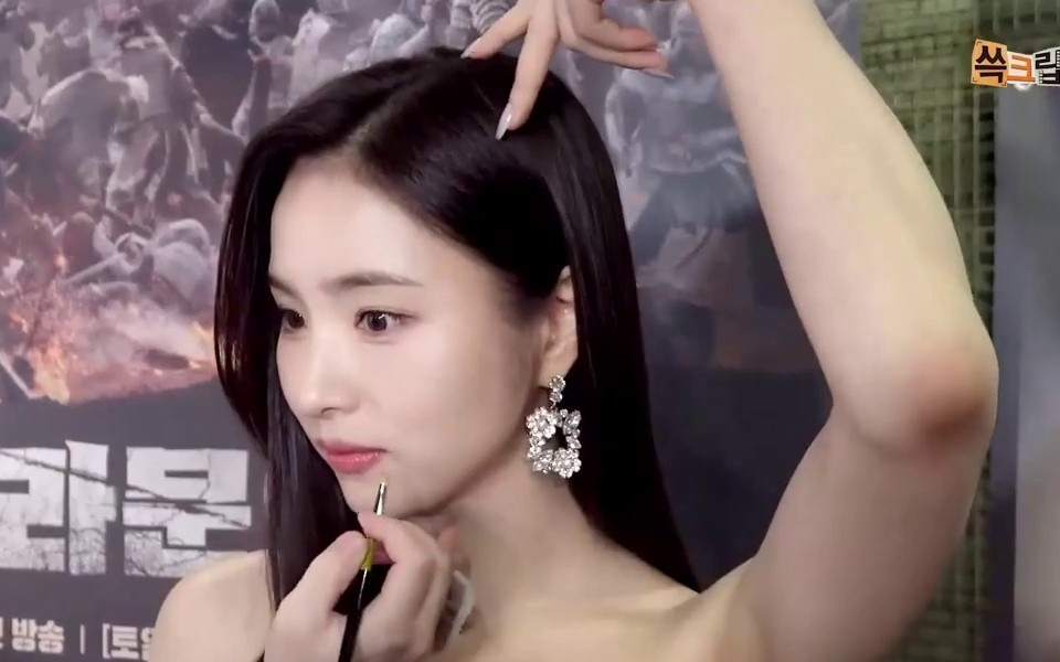 Actor Shin Se-kyung draws a heart over her head in a black dress