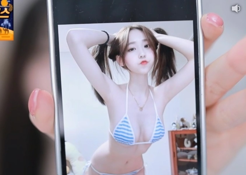 Jjami shows a picture of a striped bikini during a broadcast
