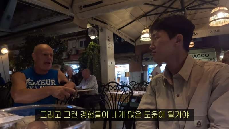 A European man gives advice to an anxious Korean youth