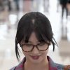 Twice Momo wearing horn-rimmed glasses and a heavy gray tank top showing off her bra in a check shirt