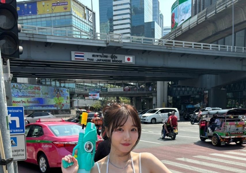 Suryeon holding a water gun, white swimsuit with holes, cleavage