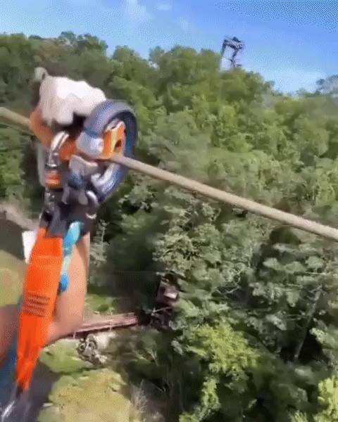 Happy wife riding a zip line with her boyfriend