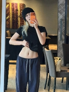 Jeon Somi lifts up her t-shirt and shows her belly button